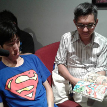 Tony Young shows his bound comics to new member Michael Shinsato.